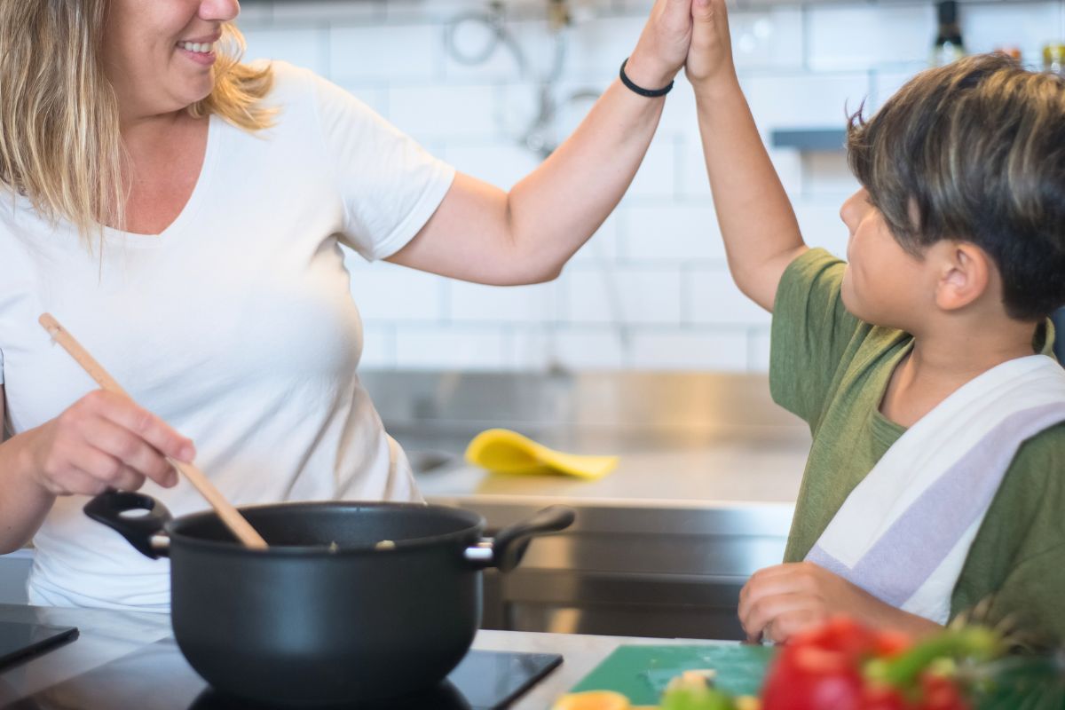 Mom and child cooking together in kitchen during family bonding activity.