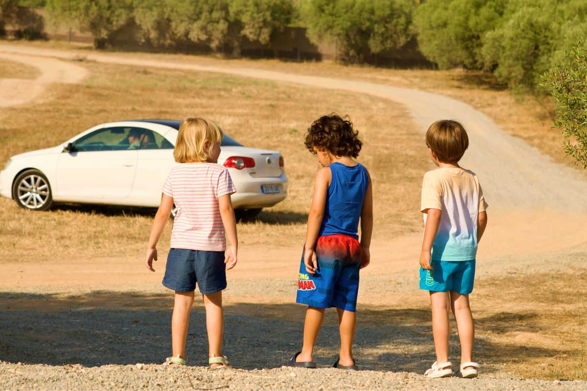 Kids exploring outdoors during family road trip adventure with parents.