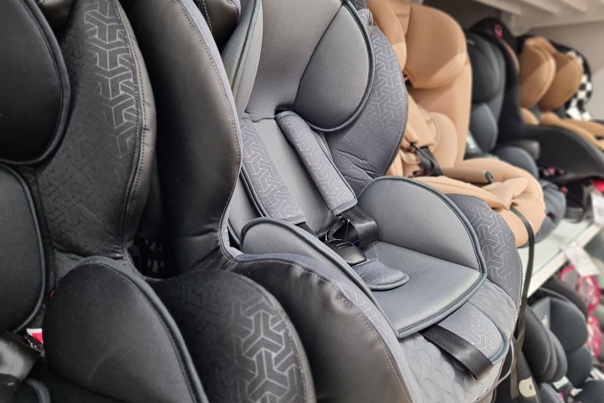 Rows of compact child car seats displayed side by side in a store.