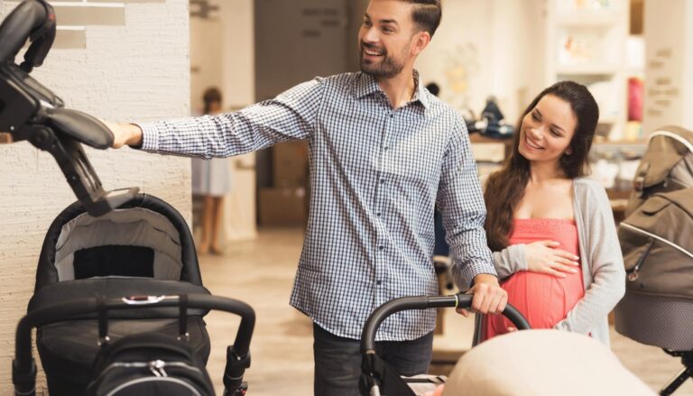 Expectant couple comparing baby strollers while shopping in a baby store.