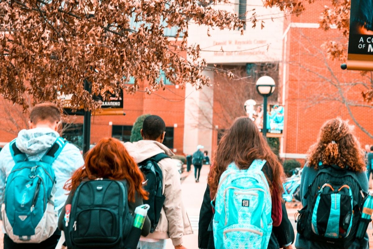 Students walking together with backpacks on a school campus.