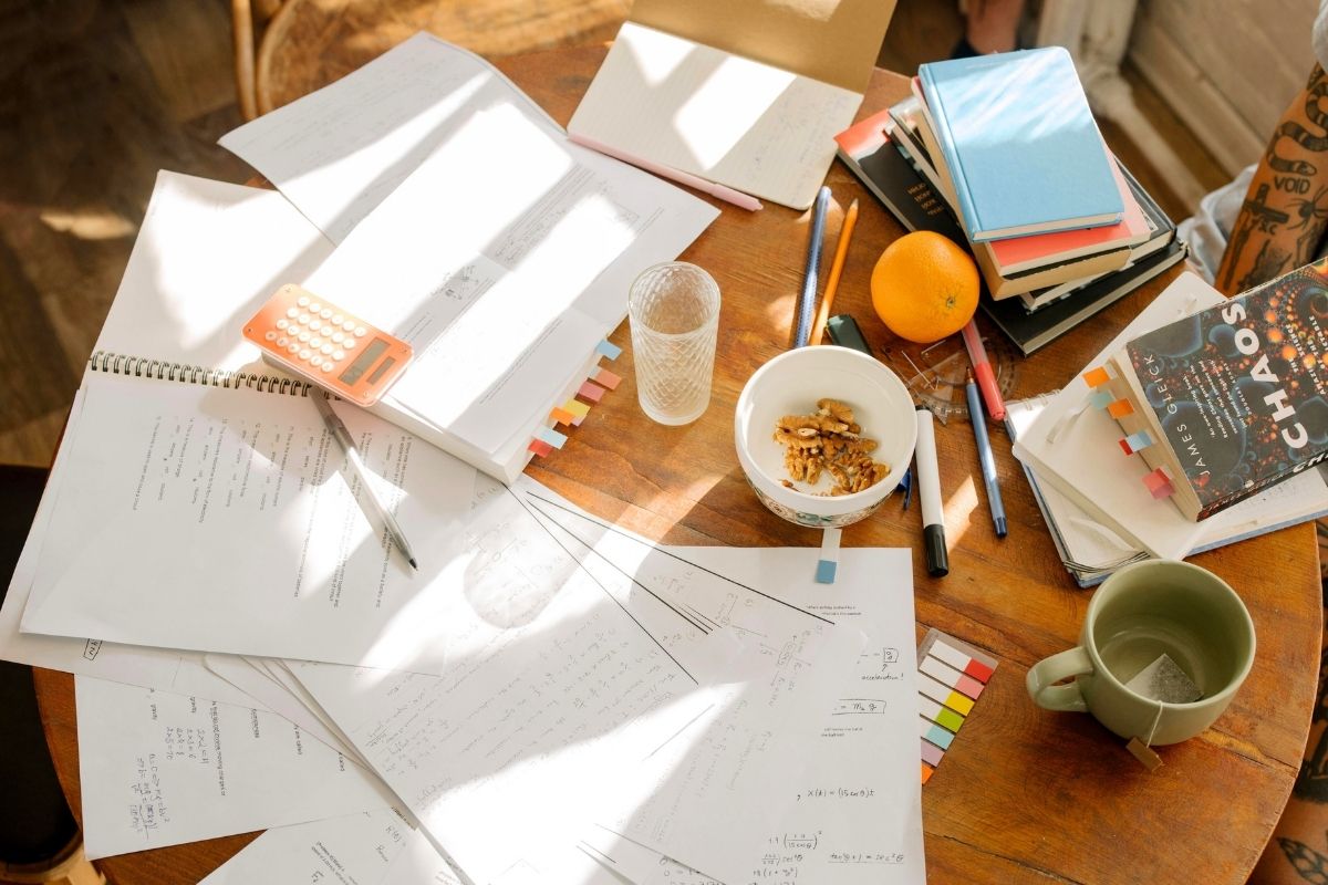 Papers, coins, and a notebook arranged on a bright desk for budgeting.