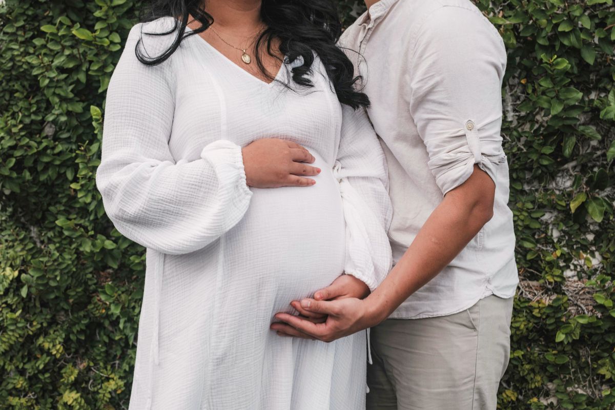 Pregnant couple holding the baby bump during a calm and romantic pre-baby getaway.
