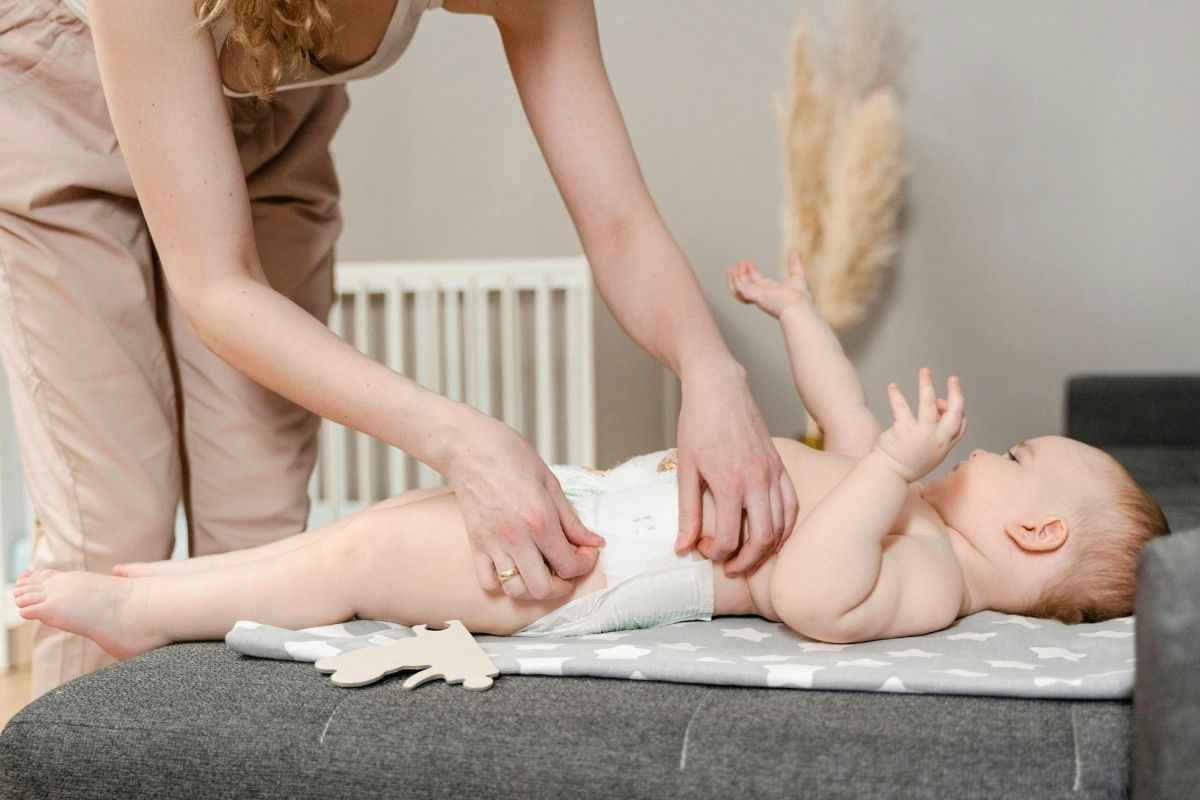 Parent changing baby’s diaper on a changing table.