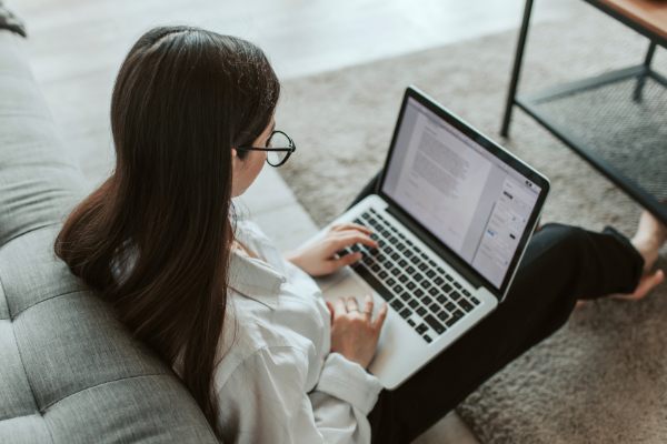 Woman working on a laptop from home, illustrating balancing work and family life.