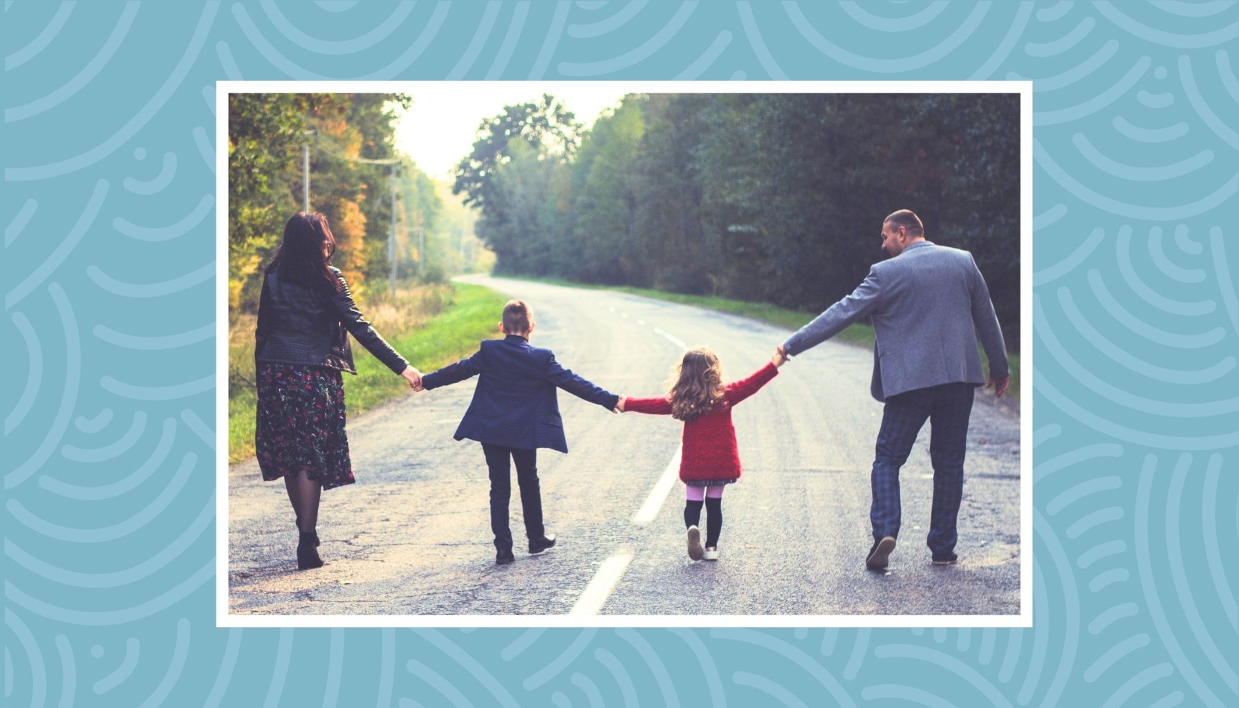 Family walking together on a scenic road during a family vacation in Canada.