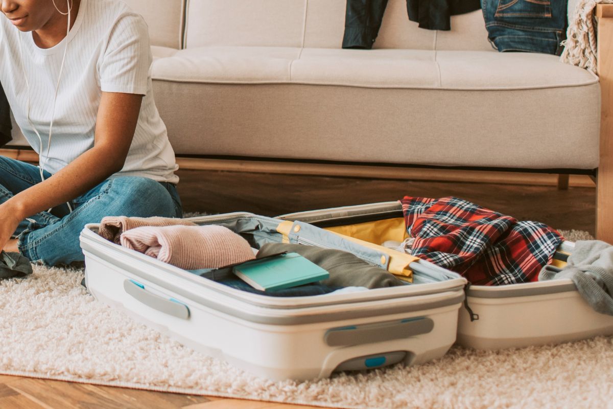 Open suitcase with packed clothes and items for a family vacation at home.
