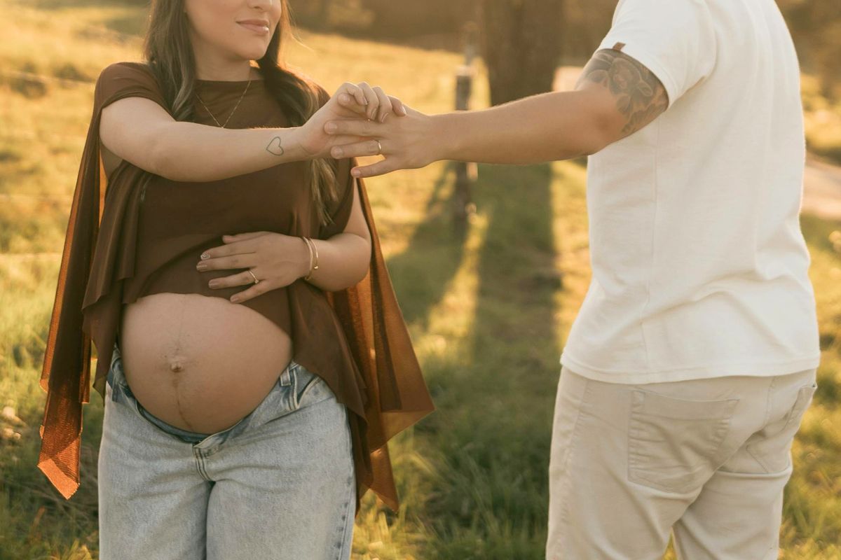 Expecting couple holding hands during a calm outdoor babymoon before baby arrives.