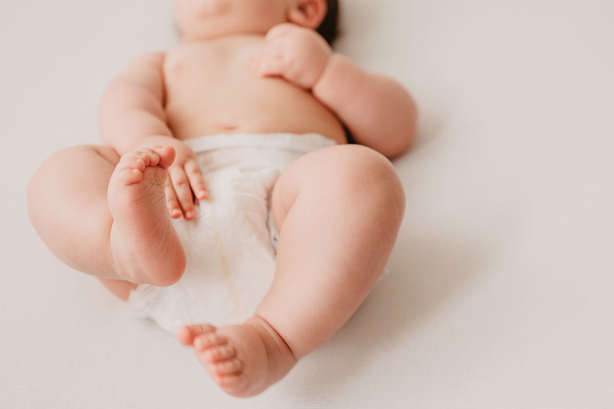 Baby lying down in a diaper, showing a relaxed moment after a diaper change.