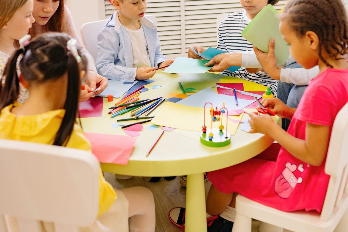 Preschool children doing arts and crafts at daycare, showing hands-on learning and a creative environment.