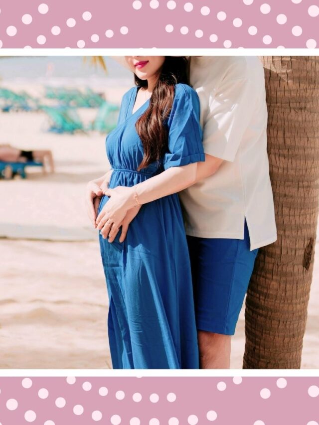 Pregnant couple posing by the beach for a relaxing all-inclusive babymoon trip before welcoming their baby.