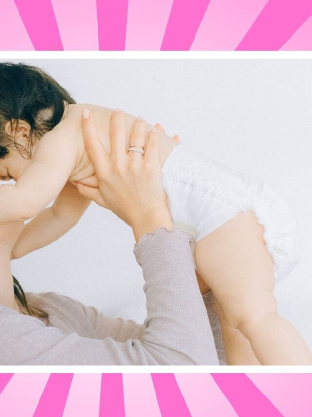 Mom lifting baby during a happy parenting moment while learning how to handle diaper blowouts and messy baby stages.