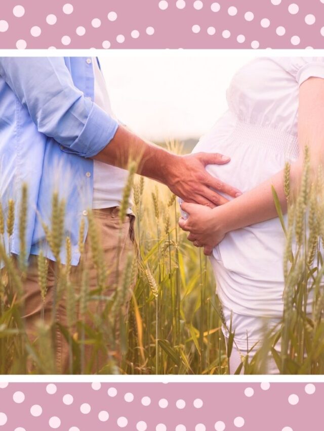 Expecting couple holding a baby bump in a field for a sweet pre-baby babymoon memory.