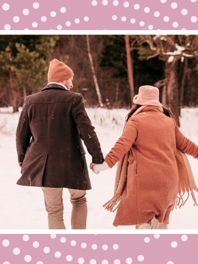 Expecting couple walking through the snow for cozy winter babymoon ideas.