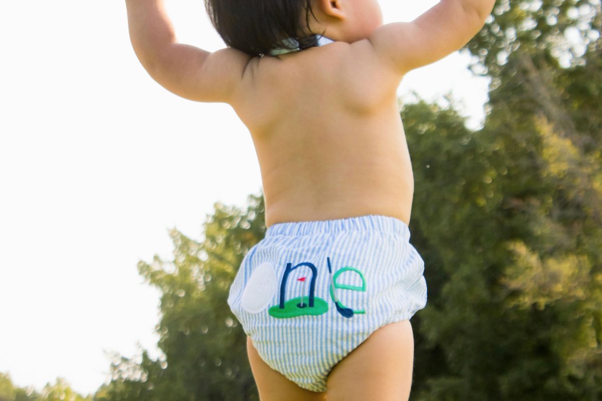 Toddler wearing a diaper outdoors during a stage where parents often deal with diaper blowouts and diaper fit issues.