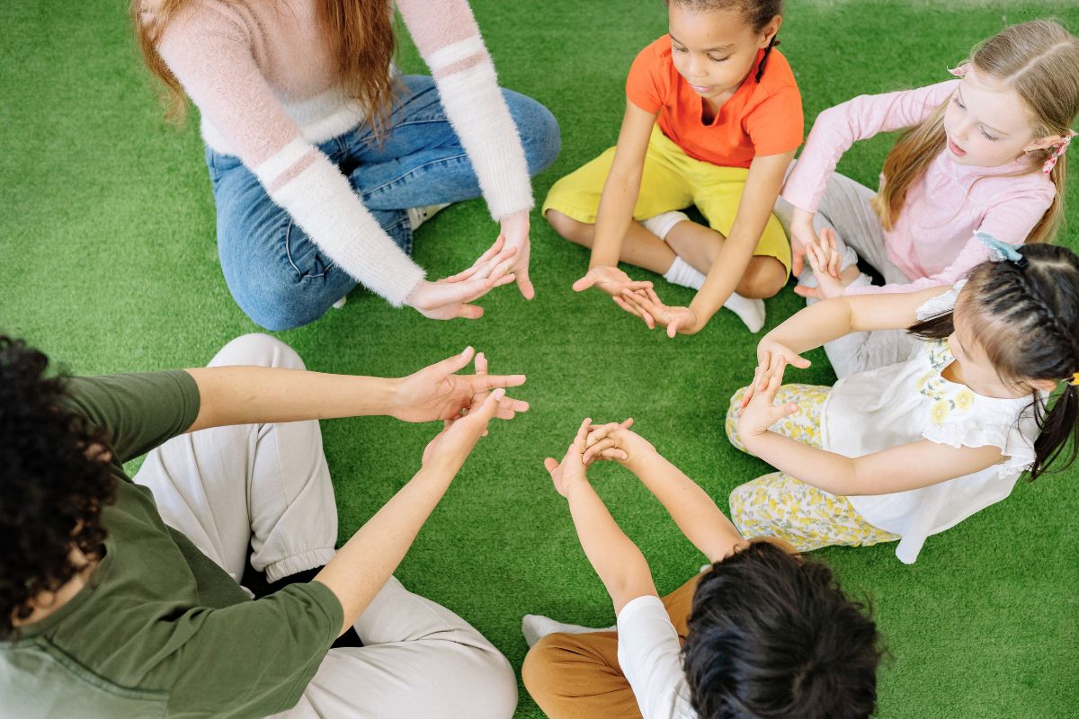 Preschool children and teachers sitting in a circle for a group activity.