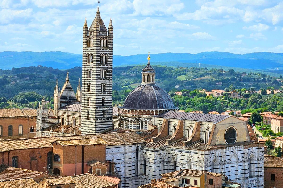 Scenic view of Siena, Tuscany, with the cathedral and rolling hills in the background.