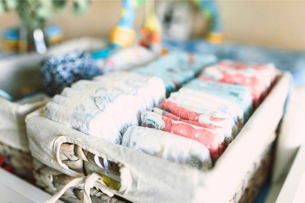 Stack of folded reusable cloth diapers arranged on a shelf.