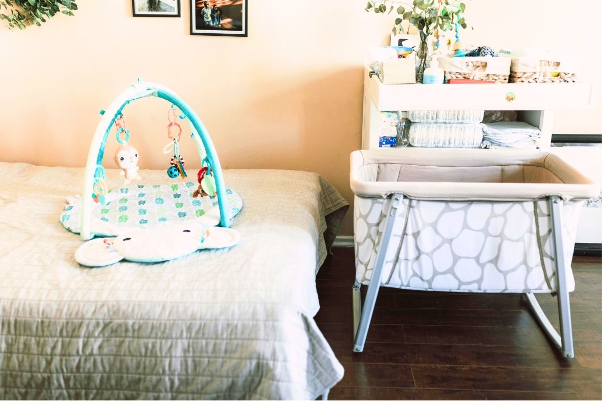 Nursery corner with a crib, baby mobile, and neatly arranged baby essentials.