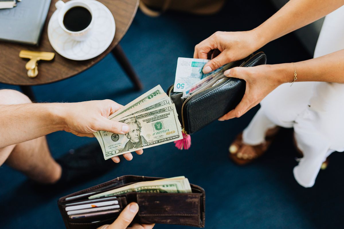 Paying with cash from a wallet as part of managing a household budget and daily spending.