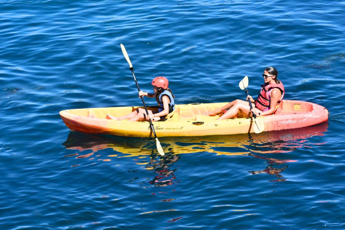Parent and child kayaking together on a Canadian lake, enjoying a family-friendly outdoor adventure.