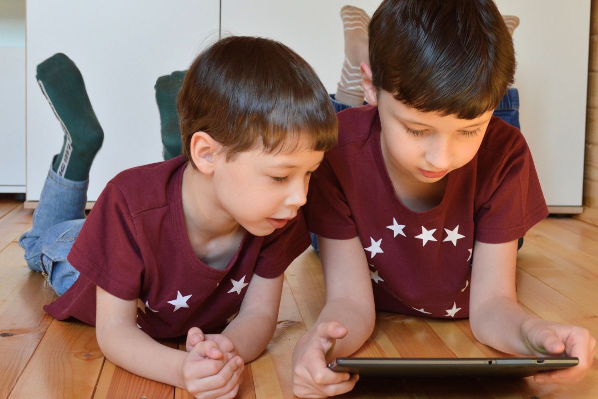 Two children watching YouTube Kids on a tablet together at home.