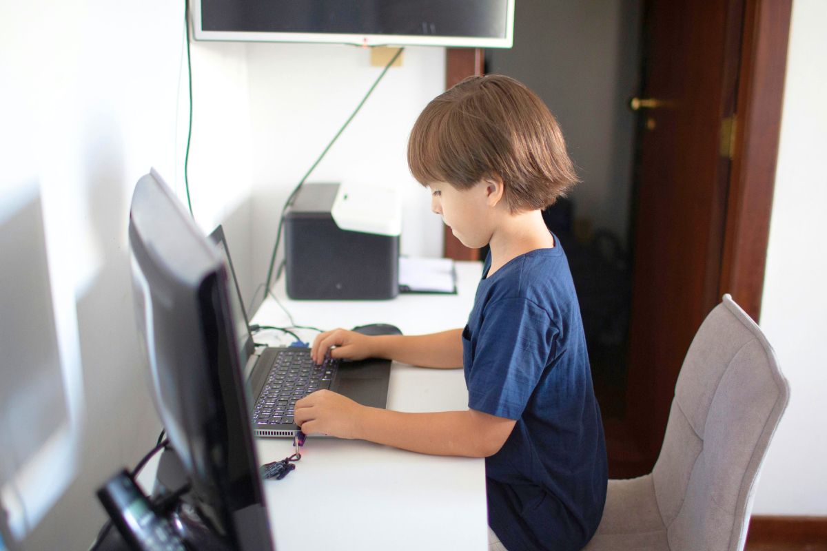 Child using a computer at home with YouTube Kids safety and screen time rules.
