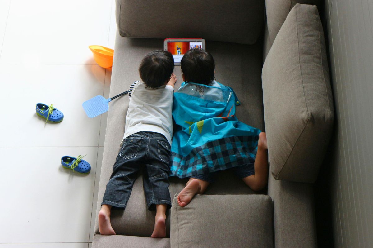 Two young children watching YouTube Kids together on a tablet at home.
