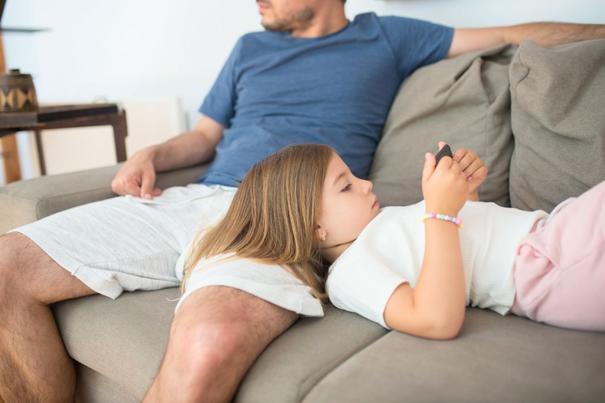 Child using a phone while practicing healthy screen time habits with family.