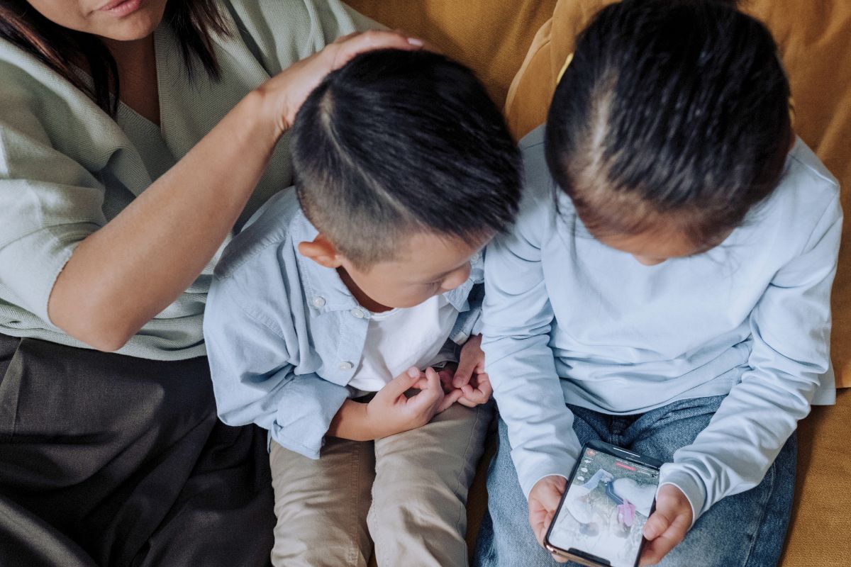 Parent guiding children through healthy screen time rules at home.