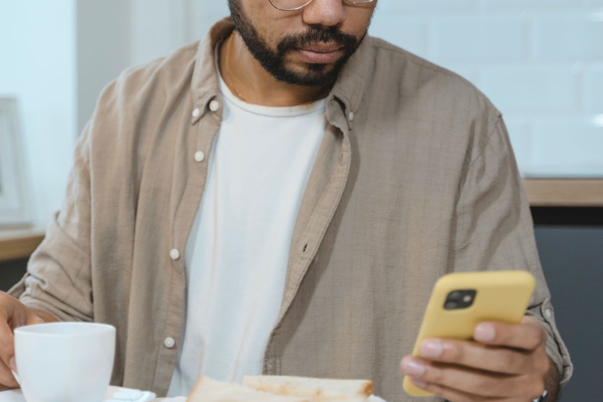 Busy parent using ChatGPT on a smartphone to find quick homework help ideas before helping their child.