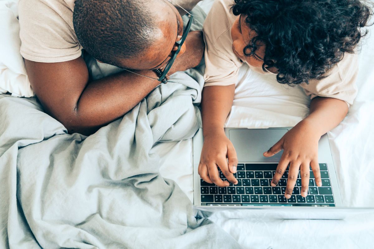 Parent and child using a laptop together to review homework with ChatGPT in a relaxed home setting.