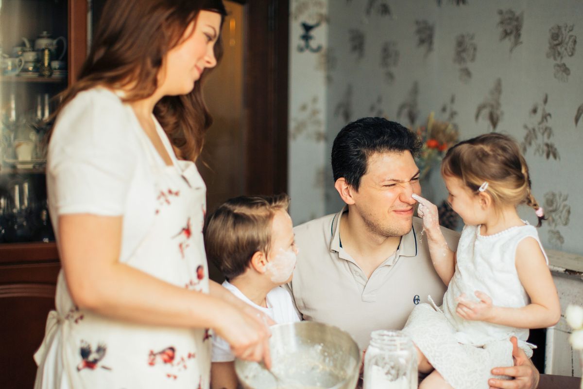 Parent and children baking together while practicing gentle family connection at home.