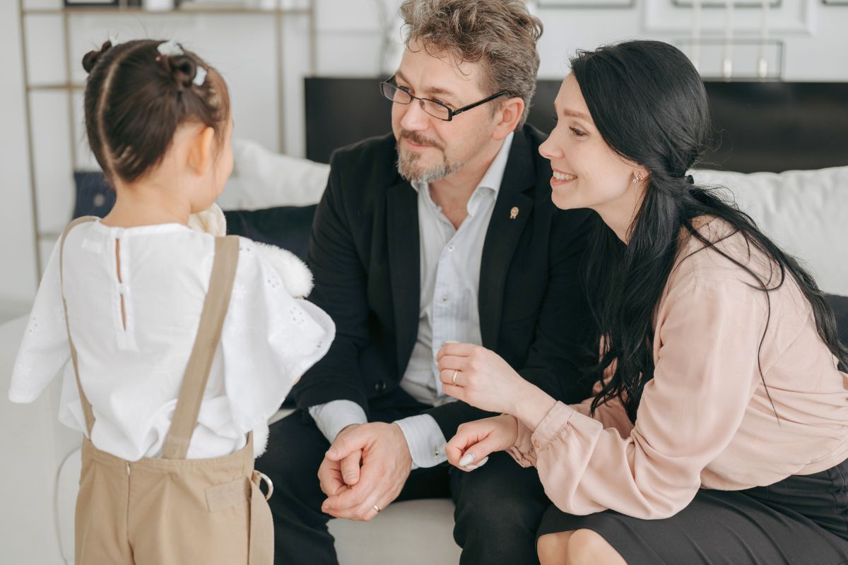 Parents calmly talking with a young child during a positive discipline moment.