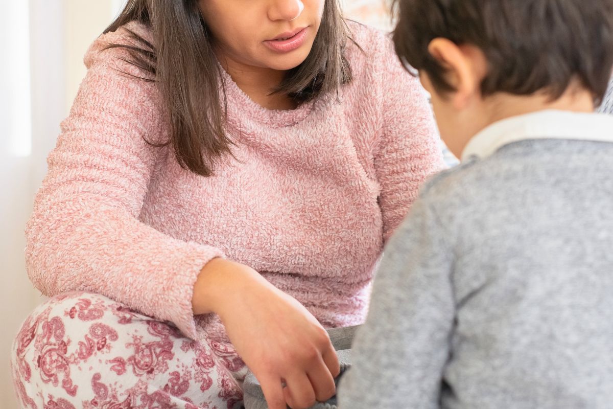 Parent talking calmly with a child during a boundary-setting moment.