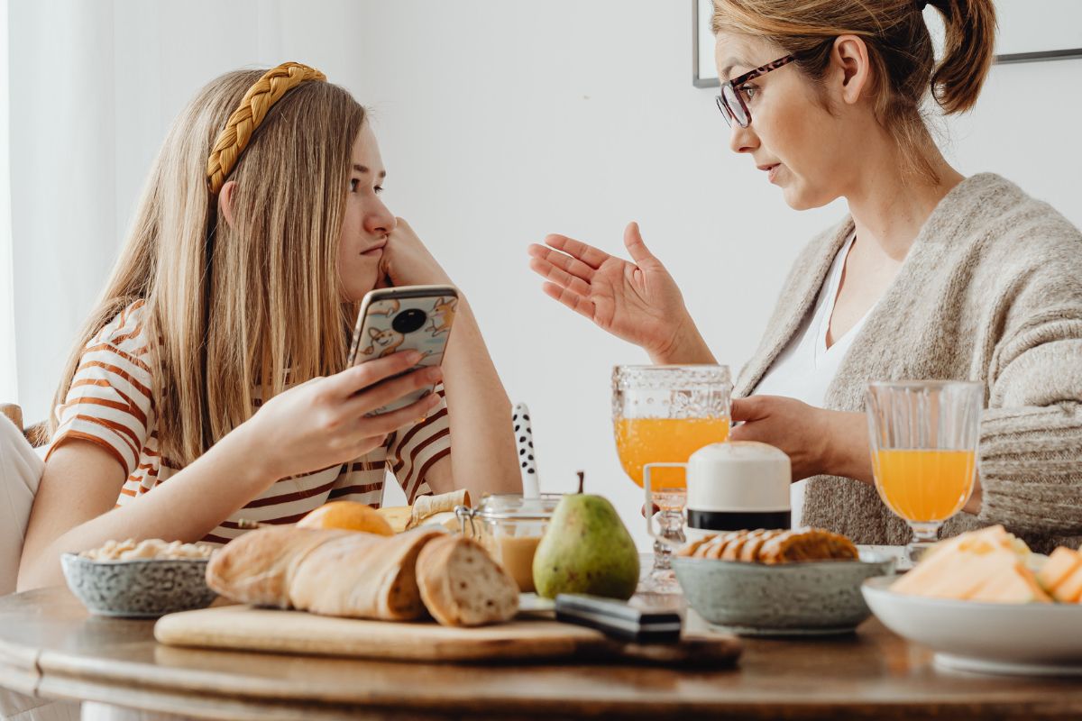 Parent setting screen time boundaries with a child at the table.