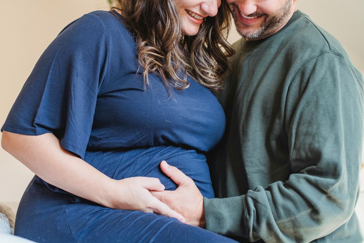 Expecting parents laughing together while holding the baby bump, a warm and romantic moment during pregnancy.