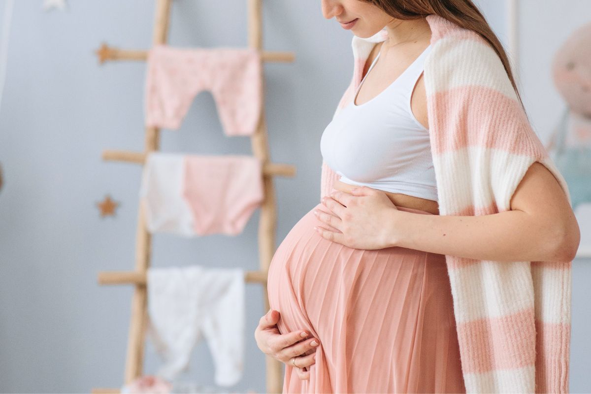 Expecting mom organizing baby clothes and preparing for newborn life at home.