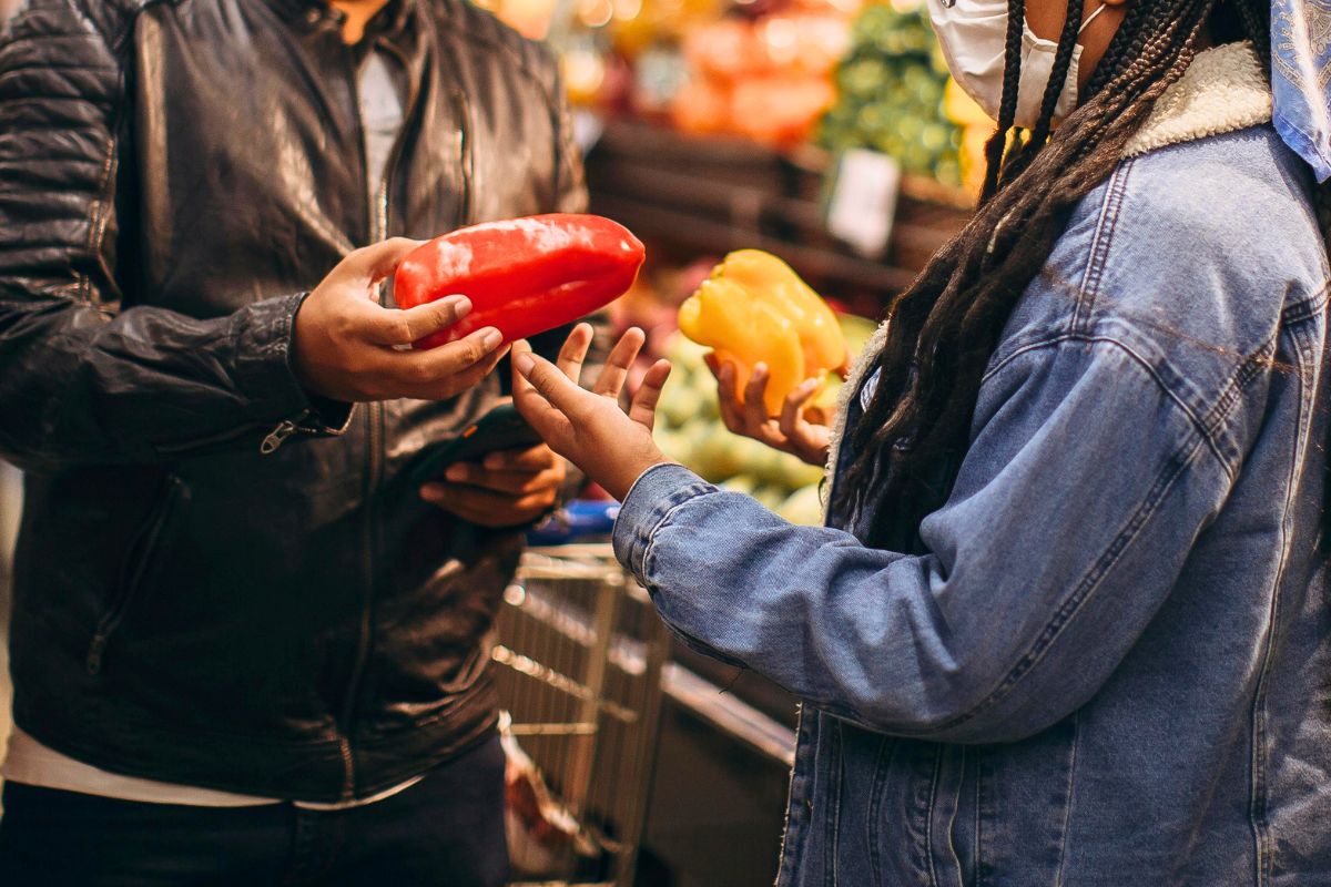 Comparing fresh vegetables while grocery shopping on a family budget.
