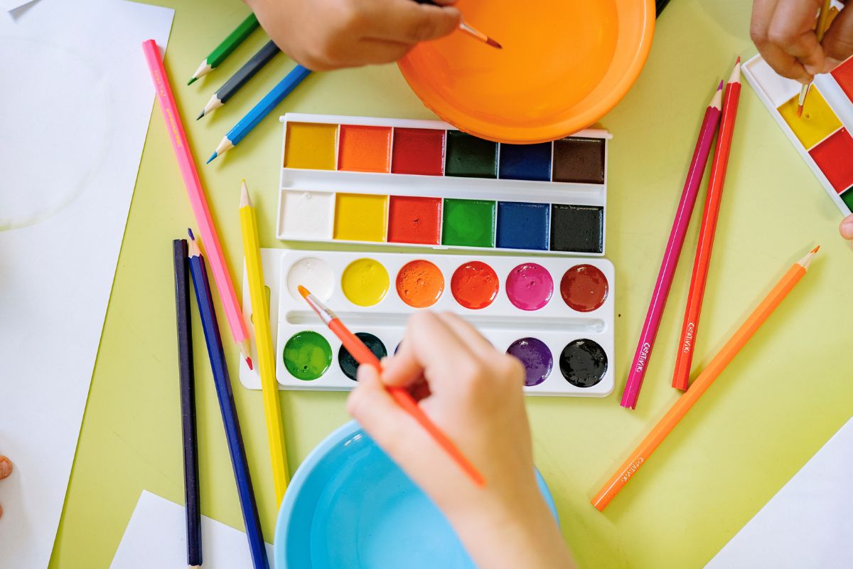 Kids painting and doing arts and crafts during a summer staycation activity.
