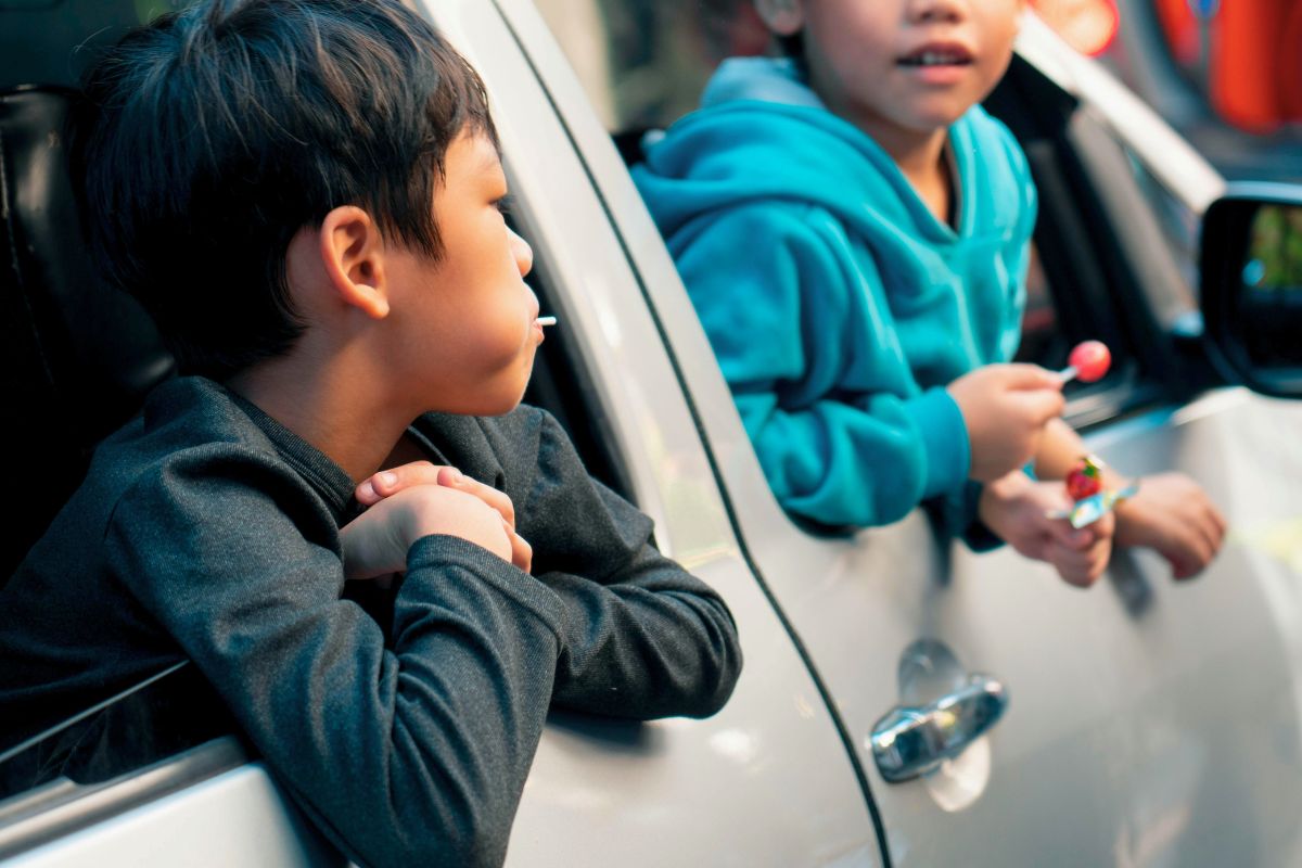 Kids enjoying snacks during a family summer road trip staycation.
