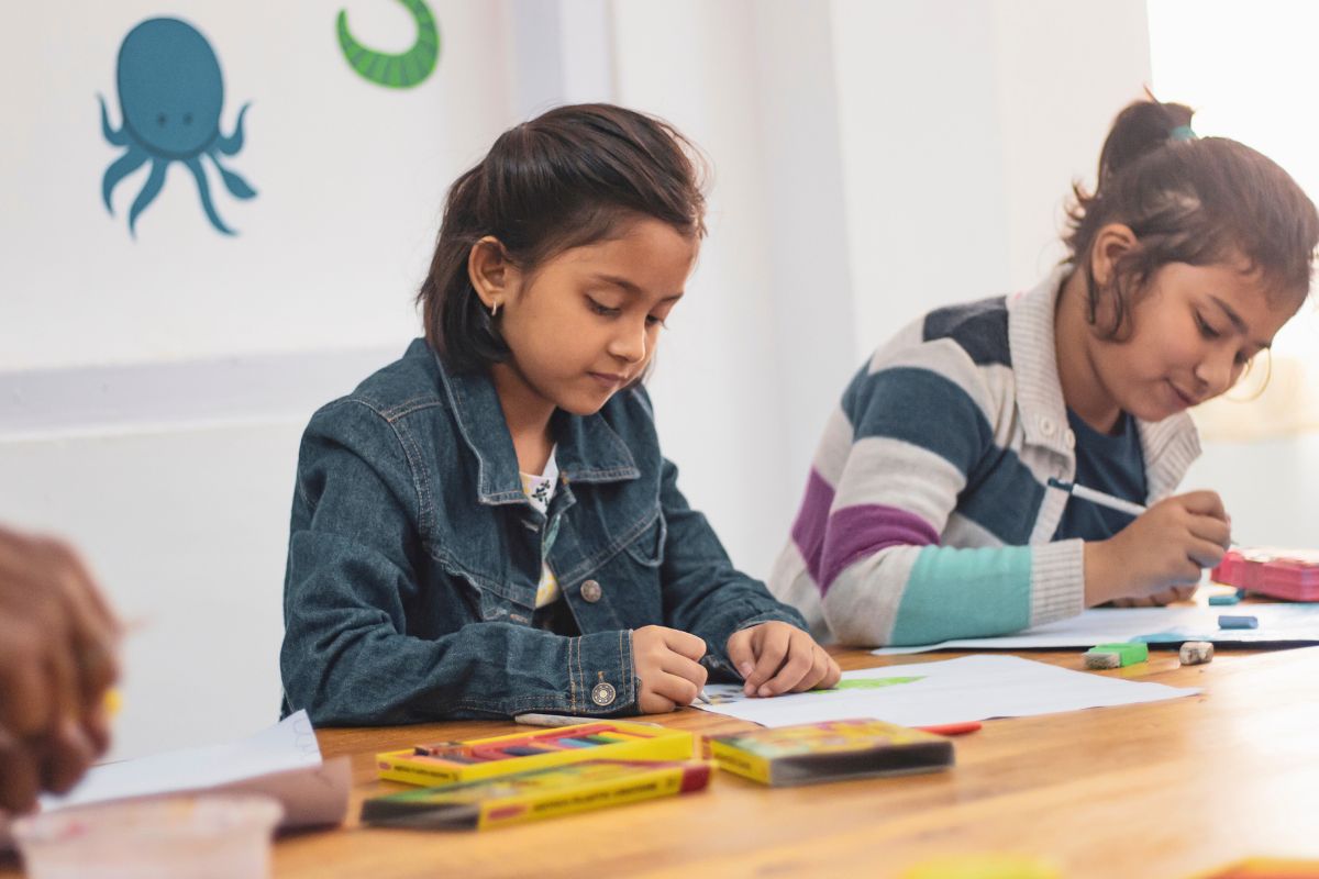 Students using crayons and school supplies during a classroom activity after back-to-school shopping.
