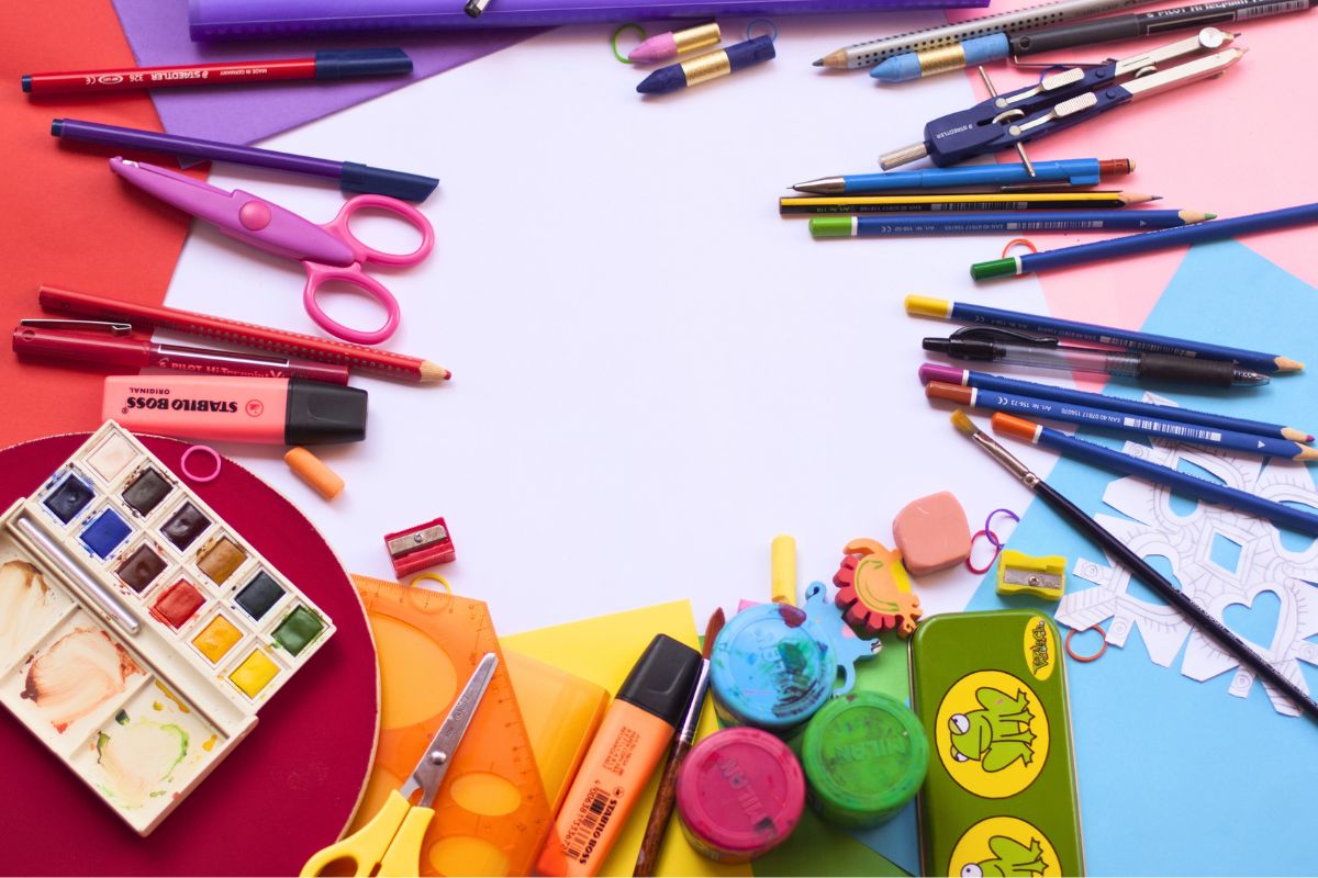 Back-to-school supplies, including pencils, scissors, rulers, paint, and stationery, arranged for a school shopping checklist.