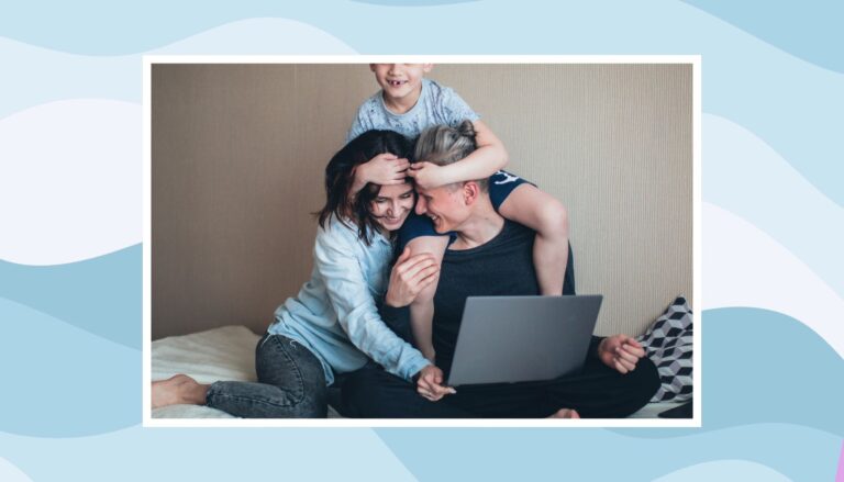 Two parents and their child gathered around a laptop during a family technology learning activity.