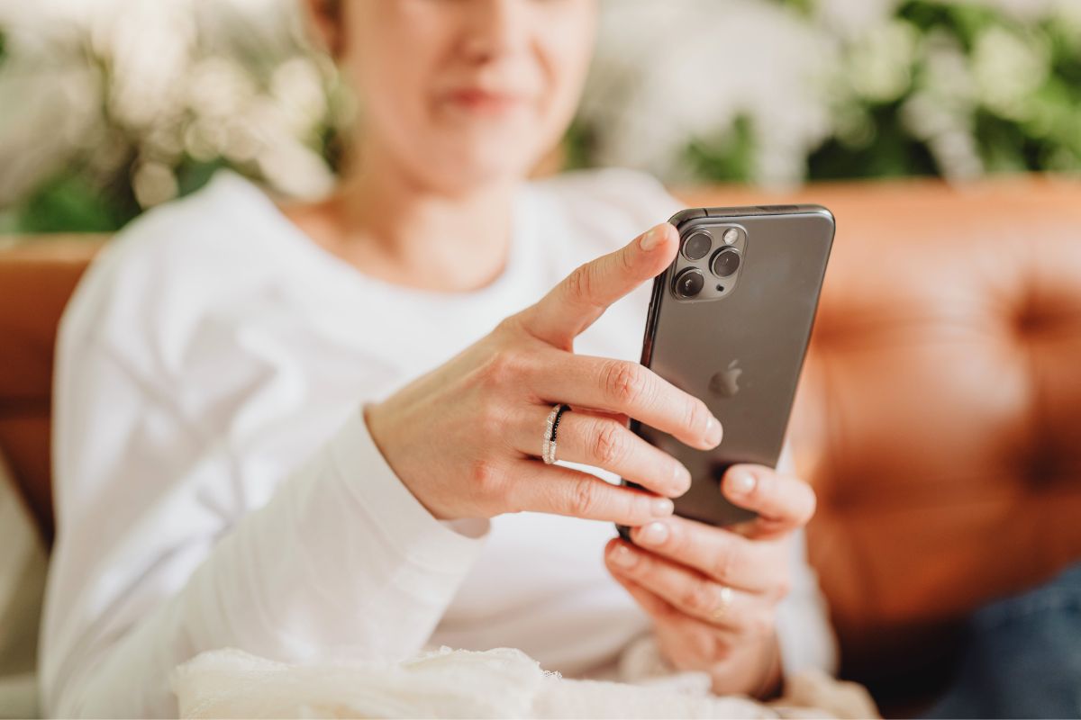 Mom using ChatGPT prompts for parents on her smartphone to find quick parenting ideas and family routines.