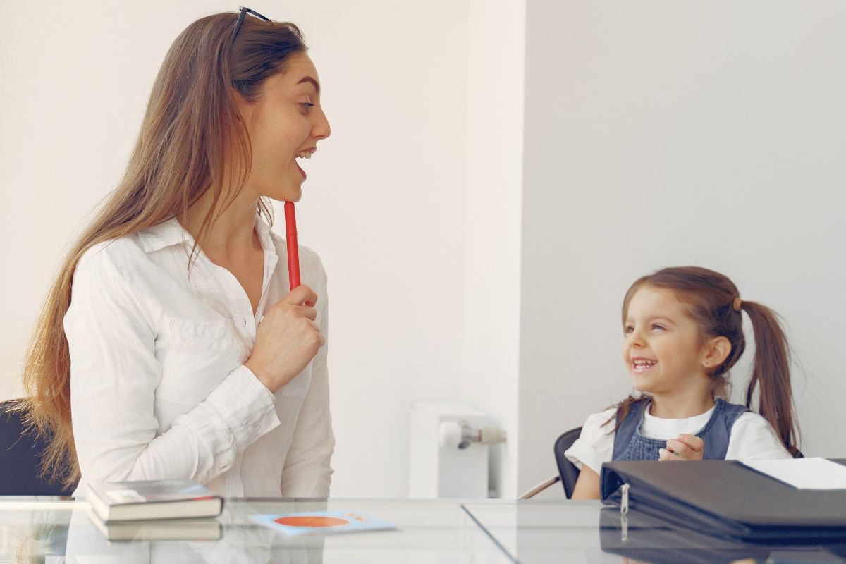Mom talking with a smiling kindergarten before the first day of school.