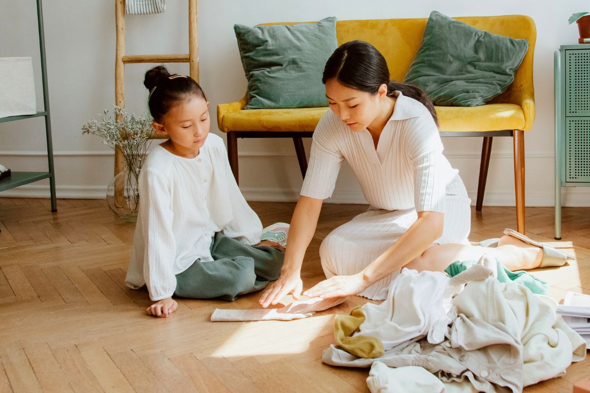Parent helping a child choose and prepare comfortable clothes for the first day of kindergarten.