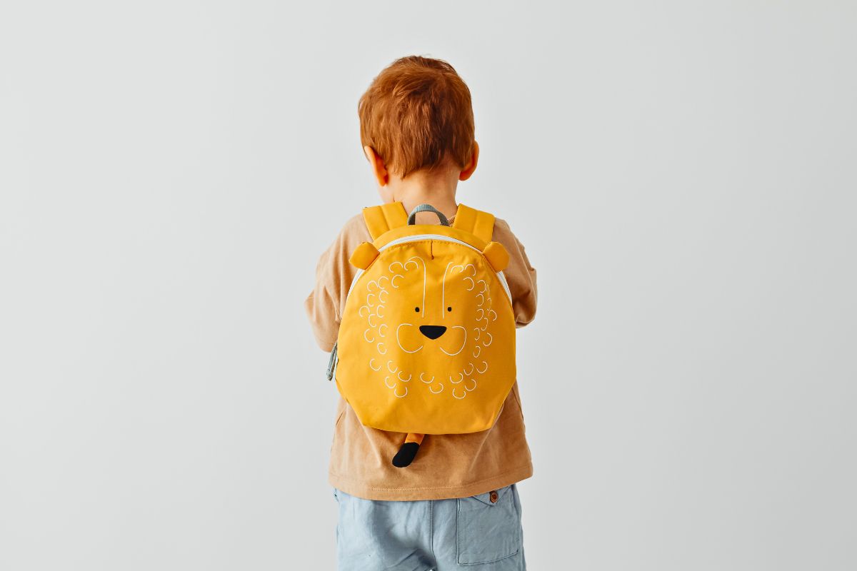 Child wearing a backpack, kids carry on essentials for travel.