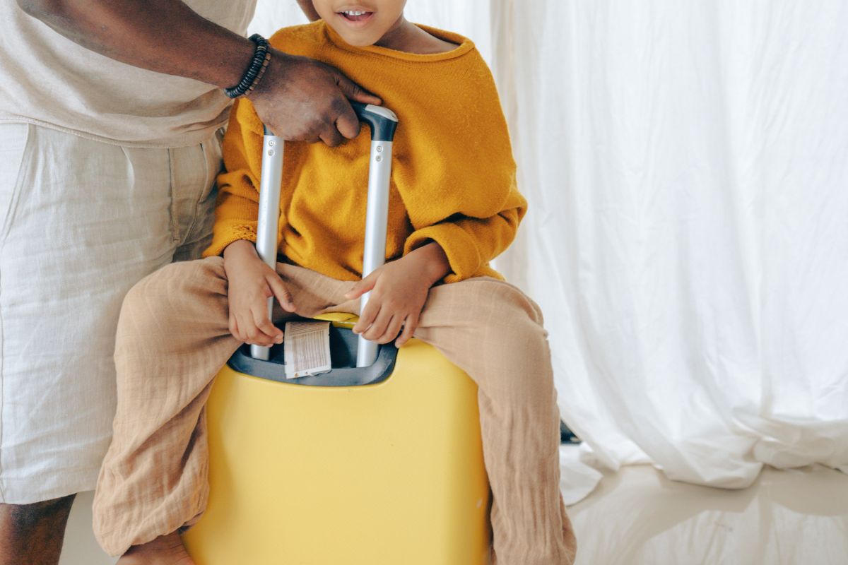 Kid sitting on ride-on luggage, best kids carry on for travel.