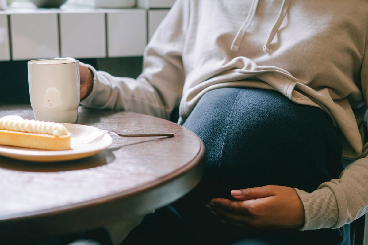 Pregnant mom enjoying a quiet cafe moment during a relaxing winter babymoon getaway.